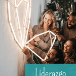 Un equipo diverso de profesionales en una oficina moderna en Madrid trabaja unido para construir una red geométrica luminosa en una pared, simbolizando la colaboración y el liderazgo horizontal sin un líder único.